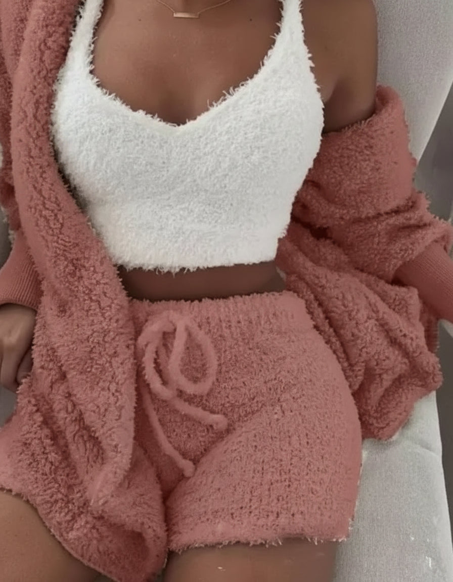 Person wearing a white fuzzy top and pink shorts with a matching cardigan.